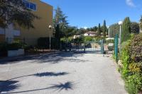 a driveway with a fence and trees and a building at Les jardins de Bandol, piscine et mer in Bandol