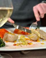 a person eating a plate of food with a fork and knife at B&B Del Centro e SPA in Partinico