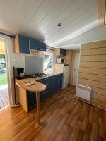 a kitchen with blue cabinets and a wooden floor at Bungalow pour 5 - TV - Clim - Terrasse ensoleillée in Boofzheim