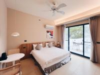 a bedroom with a bed and a table and a window at Qixingtan Xinghai B&amp;B in Dahan