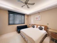a bedroom with a bed and a ceiling fan at Qixingtan Xinghai B&amp;B in Dahan