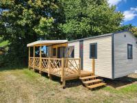 une petite maison avec une terrasse couverte et une terrasse dans l&#39;établissement Camping le Balcon de la Baie, à Saint-Marcan
