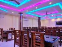 ein Esszimmer mit violetten Lichtern an der Decke in der Unterkunft The Triton Beach Resort in Mandarmani