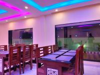 ein Esszimmer mit einem Tisch, Stühlen und violetten Lichtern in der Unterkunft The Triton Beach Resort in Mandarmani