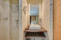a bathroom with a shower and a sink and a mirror at Hostellerie Le Paradou in Lourmarin