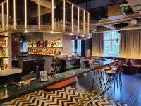 a bar in a room with a bunch of bottles at TRIBE Riga City Centre in Rīga
