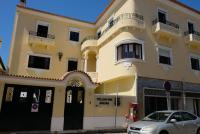 Un edificio amarillo con un coche aparcado delante. en Yellow Inn Aveiro, en Aveiro