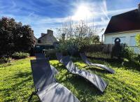eine Gruppe von Stühlen, die im Gras auf einem Hof sitzen in der Unterkunft Maison Kérity with Jacuzzi – Terrace in Paimpol