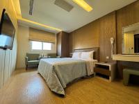 a hotel room with a bed and a television at Ai Lai Fashion Hotel in Taichung