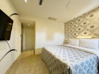 a bedroom with a bed and a flat screen tv at Ai Lai Fashion Hotel in Taichung