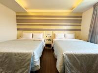 two beds in a hotel room with two beds sidx sidx sidx at Ai Lai Fashion Hotel in Taichung