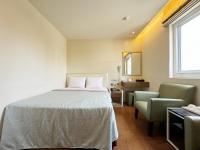 a bedroom with a bed and a chair at Ai Lai Fashion Hotel in Taichung