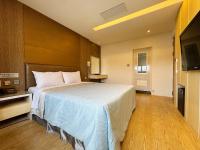 a hotel room with a bed and a television at Ai Lai Fashion Hotel in Taichung