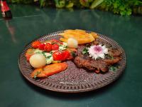 Un plato de comida con carne y verduras en una mesa. en MOTEL STUDIO A, en São Paulo