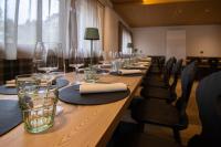 a long wooden table with wine glasses and chairs at Chalet Cridola Dolomiti Experience in Lorenzago