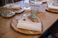 a wooden table with glasses of wine on it at Chalet Cridola Dolomiti Experience in Lorenzago