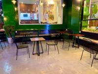 un ristorante con tavoli e sedie e una parete verde di Carnival Villa a Da Lat