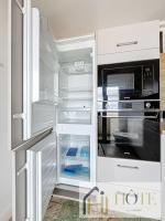 a white refrigerator with an open door with a microwave at Résidence Saint Pierre: Vue Mer, 2 Chambres in Bray-Dunes