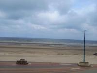 a beach with a light pole and the ocean at Résidence Saint Pierre: Vue Mer, 2 Chambres in Bray-Dunes