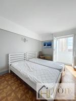 a white bed in a room with a window at Résidence Saint Pierre: Vue Mer, 2 Chambres in Bray-Dunes
