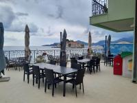 a patio with tables and chairs and the ocean at Royal Holiday Apartments Sveti Stefan in Sveti Stefan