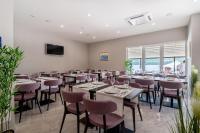 Un restaurante con mesas y sillas en una sala. en Hotel Novum, en Neum