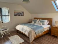 a bedroom with a bed and a chair and a window at Hollies hideaway in Donegal
