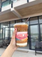 Mekong pano villa في ناخون فانوم: يد تمسك كوب من القهوة البلاستيكية