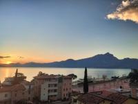 Una vista de una ciudad y el océano al atardecer. en Hotel Ristorante Al Caminetto WorldHotels Crafted Adults Only, en Torri del Benaco