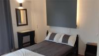 a small bedroom with a bed and a mirror at Skiathos Holiday Resort in Skiathos