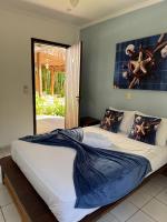 a bedroom with a large bed with a blue blanket at Pousada Estrela do Mar in Maresias