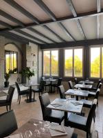 une salle à manger avec tables, chaises et fenêtres dans l'établissement Domaine de la Courbe Hôtel & Spa, au Lude