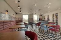 Un restaurante con mesas y sillas en una sala. en Manifest Restaurant and Hotel Gyumri, en Gyumri