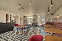 Un restaurante con mesas y sillas y un bar. en Manifest Restaurant and Hotel Gyumri, en Gyumri