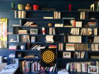 a book shelf filled with lots of books at Maison aux portes de Paris in Pantin