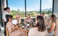 een groep mensen die rond een tafel met wijnglazen zitten bij Benguela Cove - Lavender Dreams in Hermanus
