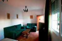 a living room with two blue couches and a table at Casa Rural El Limonero in Los Naveros
