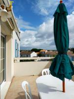 a green umbrella sitting on a table on a balcony at Grand T3 bien équipé , standing , calme in Vaux-sur-Mer