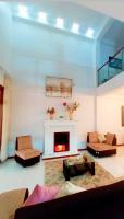 Una sala de estar con chimenea y un sofá. en Deluxe Hotel Talara a 5 minutos del aeropuerto y plaza de armas, en Talara