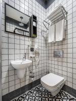 a white tiled bathroom with a sink and a toilet at Taksim Terrace Hotel in Istanbul