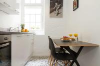a kitchen with a wooden table and chairs in a kitchen at St Germain des Prés - 2BR - CityApartmentStay in Paris