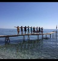eine Gruppe von Menschen, die auf einem Pier im Wasser stehen in der Unterkunft Rena's Rooms Μελίντα in Melínta