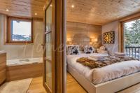 a bedroom in a log cabin with a bed and a tub at Yupik in Megève