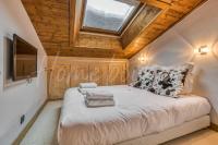a bedroom with a large bed with a skylight at Yupik in Megève