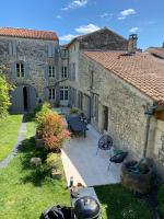 an external view of a stone house with a patio at Le Clos des Grands Frênes in Pons