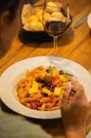 une assiette de pâtes sur une table avec un verre de vin dans l'établissement Lennox Buenos Aires, à Buenos Aires