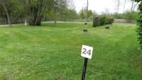 a yard with a sign in the grass at Rives Nature in La Gacilly