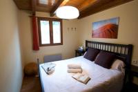 a bedroom with a large white bed with two pillows at Duplex el Pla de la Tour in Latour-de-Carol