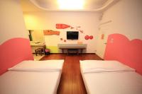 two beds in a room with a desk and a tv at Haoho in Xiaoliuqiu