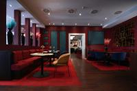 a restaurant with red walls and a red couch and tables at Hotel Haverkamp in Bremerhaven